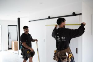 Builders measuring a door